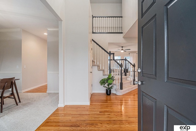 entryway with ceiling fan, ornamental molding, and light wood-type flooring