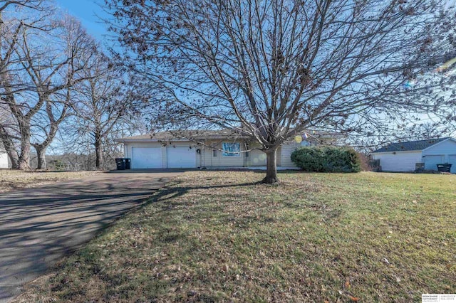 ranch-style home featuring a garage and a front lawn