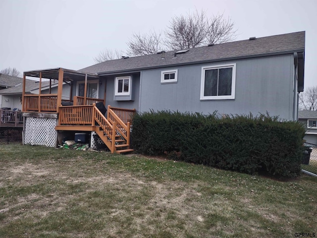 rear view of house with a lawn and a wooden deck