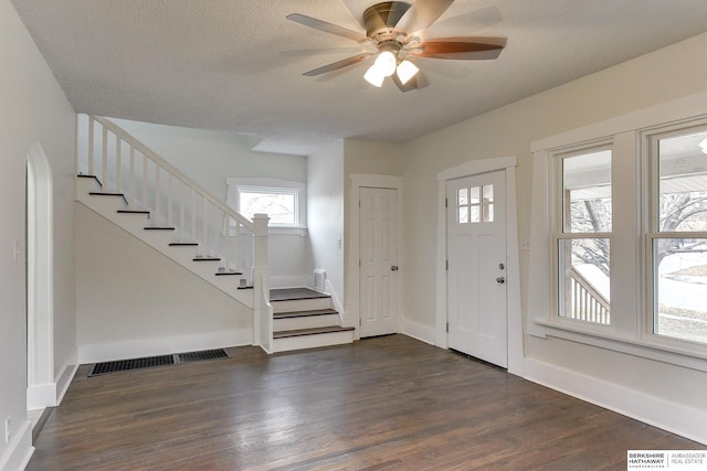 foyer entrance featuring a textured ceiling, ceiling fan, and dark hardwood / wood-style floors