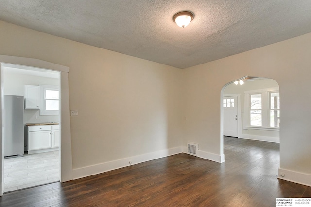 unfurnished room featuring wood-type flooring, a textured ceiling, and ceiling fan