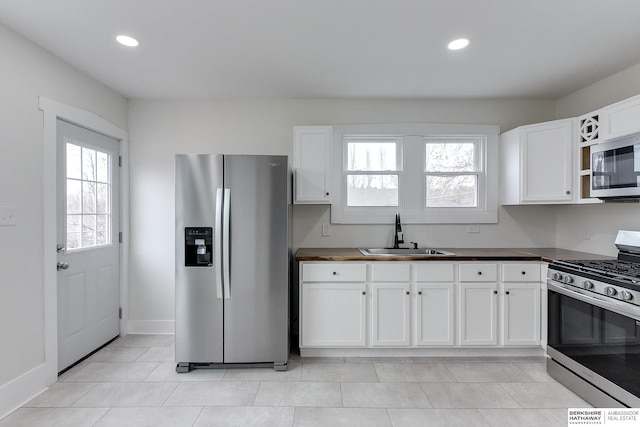 kitchen featuring white cabinetry, sink, and appliances with stainless steel finishes