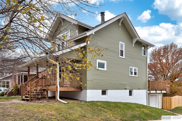 view of side of property with a deck and a yard