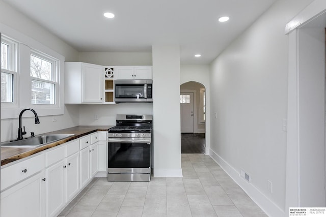 kitchen with white cabinets, sink, butcher block counters, and stainless steel appliances