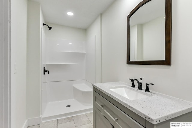 bathroom with tile patterned floors, vanity, and a shower