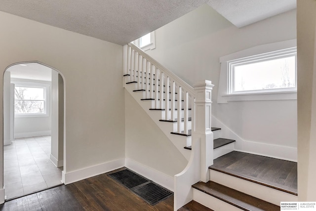 staircase featuring wood-type flooring and a textured ceiling