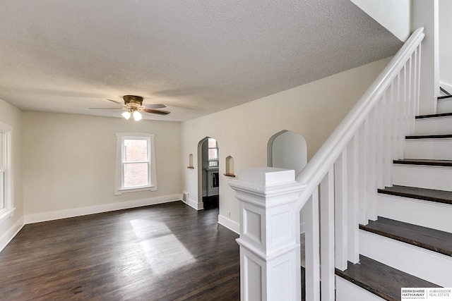 interior space featuring ceiling fan, dark wood-type flooring, and a textured ceiling