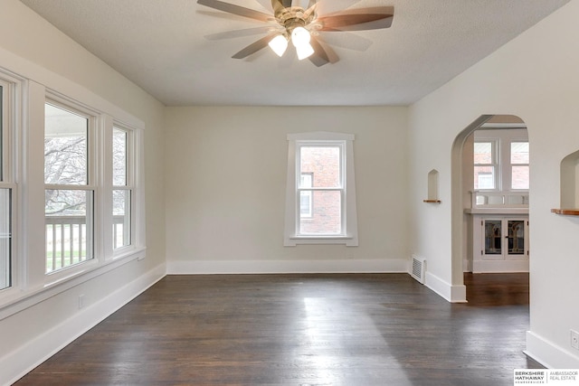 unfurnished room with ceiling fan and dark wood-type flooring