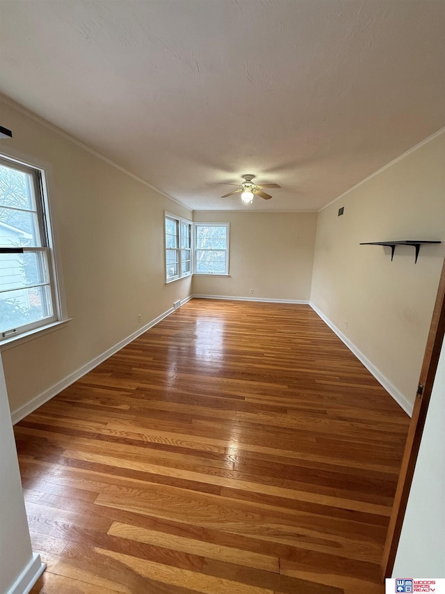 spare room featuring ceiling fan, wood-type flooring, and ornamental molding