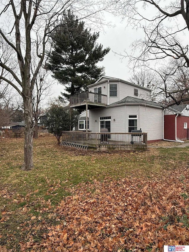 rear view of property with a lawn and a wooden deck