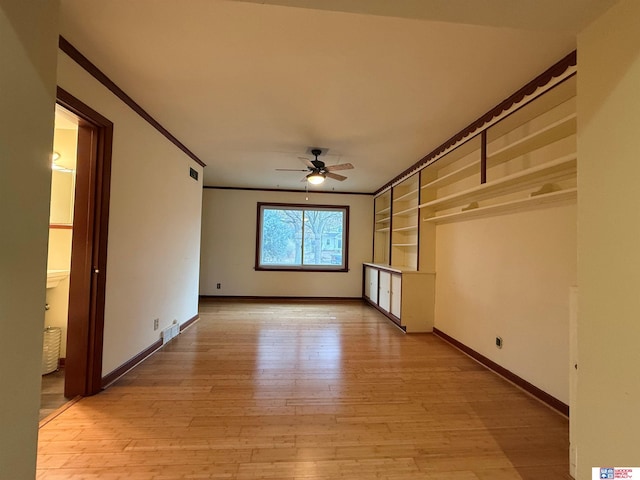 interior space featuring ceiling fan, light wood-type flooring, and crown molding