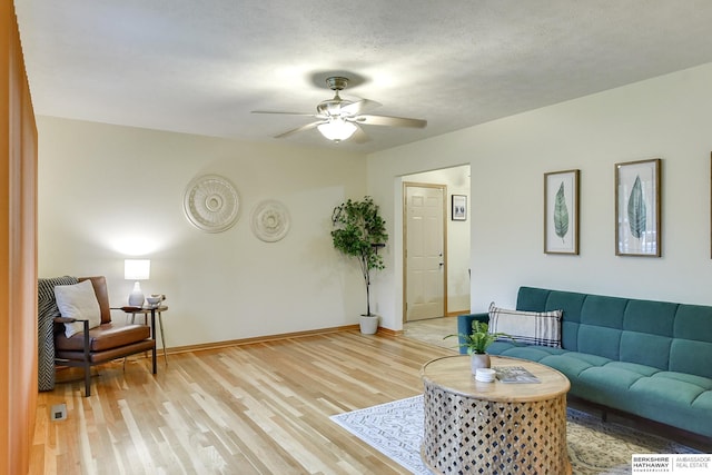 living room with ceiling fan and light hardwood / wood-style floors