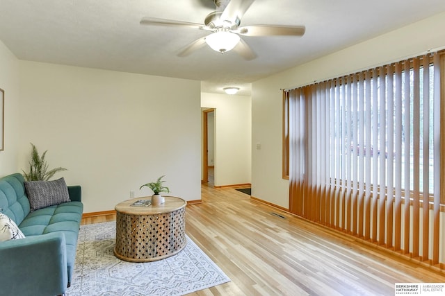 living room featuring light hardwood / wood-style flooring and ceiling fan