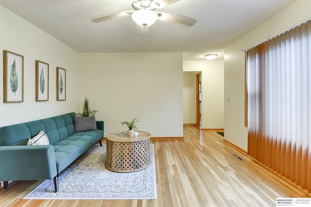 living room with light wood-type flooring and ceiling fan