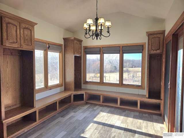 mudroom featuring hardwood / wood-style flooring, an inviting chandelier, and lofted ceiling