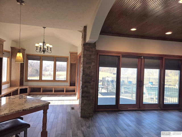 interior space with vaulted ceiling, wooden ceiling, and a chandelier