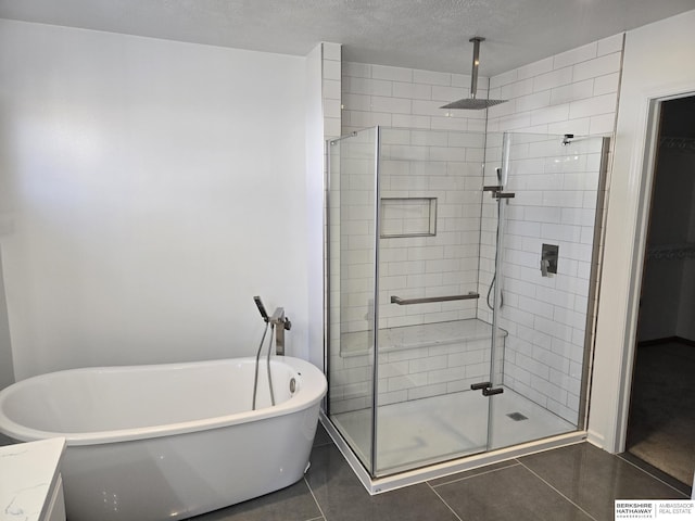 bathroom featuring tile patterned floors, separate shower and tub, and a textured ceiling