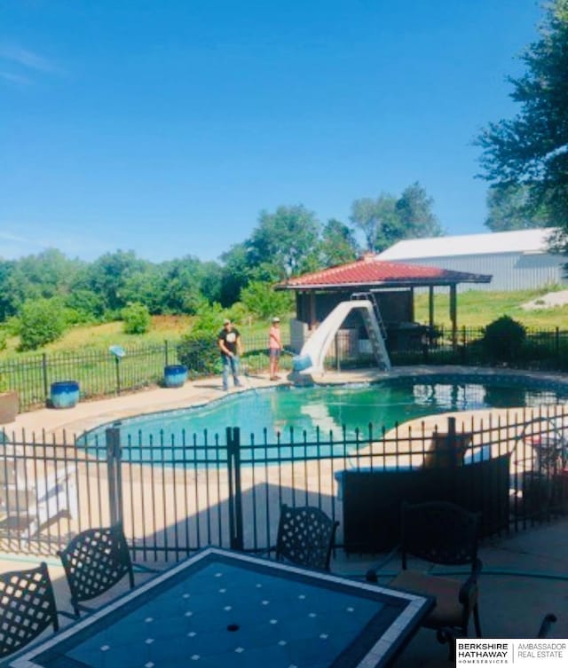 view of swimming pool featuring a patio and a water slide