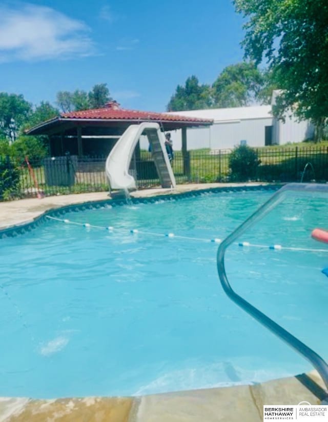 view of swimming pool with pool water feature and a water slide