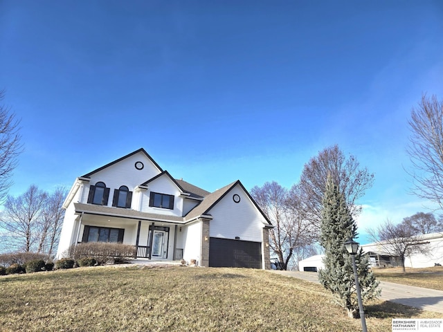 view of front of house with a porch, a garage, and a front lawn