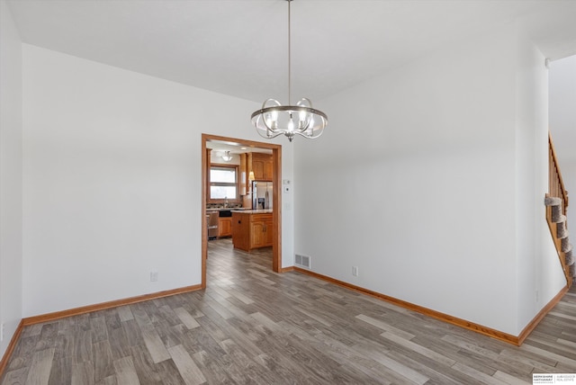 unfurnished dining area featuring light hardwood / wood-style flooring and an inviting chandelier