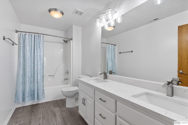 full bathroom with hardwood / wood-style floors, vanity, toilet, and shower / bath combo with shower curtain