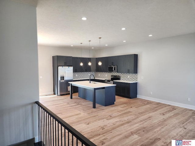 kitchen featuring a kitchen breakfast bar, tasteful backsplash, stainless steel appliances, pendant lighting, and an island with sink