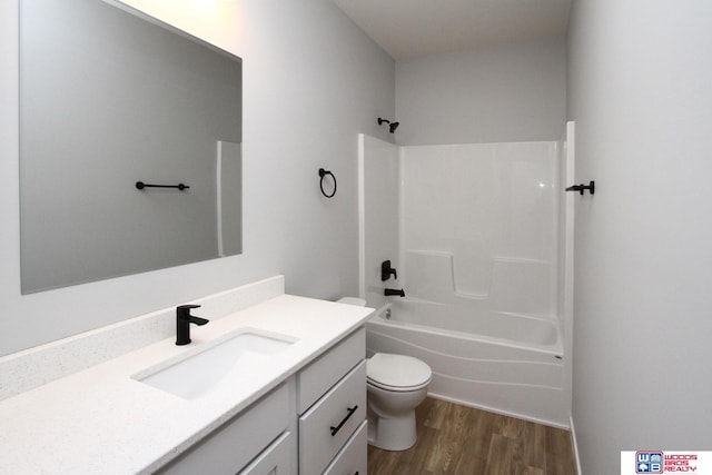 full bathroom featuring hardwood / wood-style floors, vanity, toilet, and washtub / shower combination