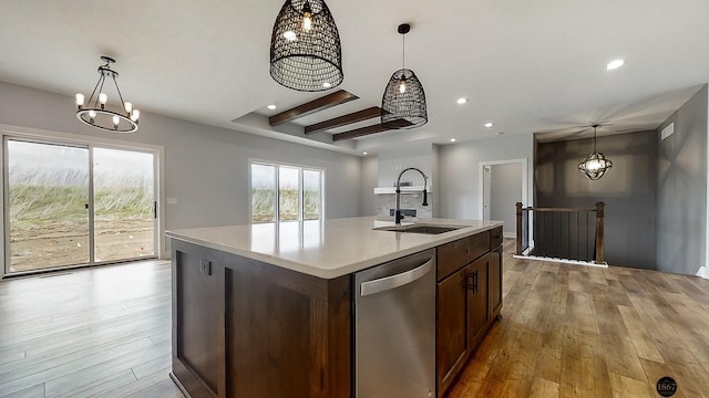 kitchen featuring pendant lighting, a kitchen island with sink, sink, light hardwood / wood-style flooring, and stainless steel dishwasher