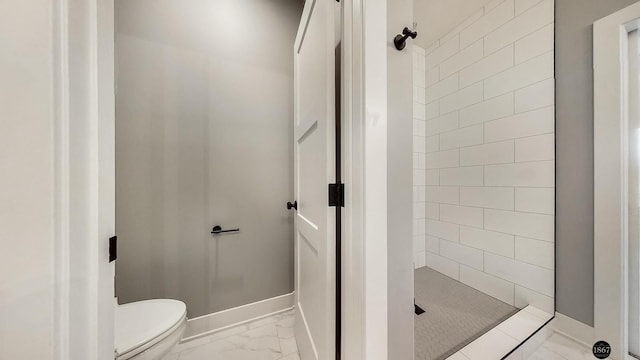 bathroom with toilet and tiled shower