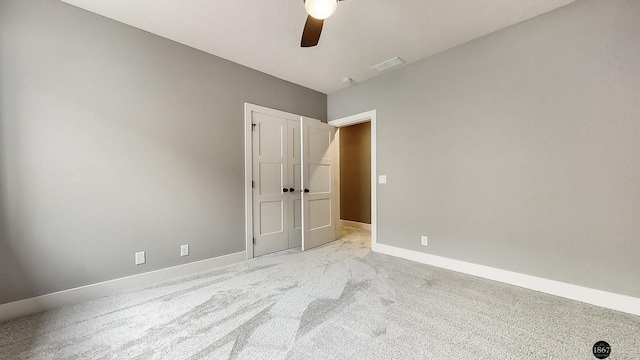 carpeted spare room with ceiling fan