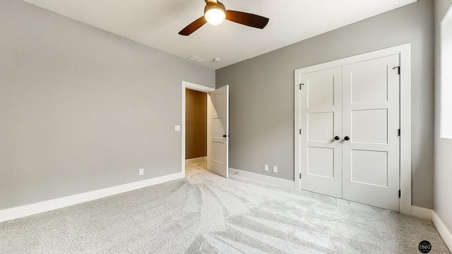 unfurnished bedroom featuring a closet, light colored carpet, and ceiling fan