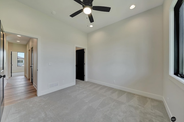 unfurnished bedroom featuring ceiling fan and light carpet