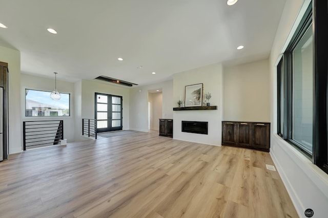 unfurnished living room with light hardwood / wood-style flooring and french doors