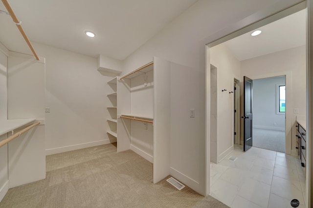 spacious closet with light colored carpet