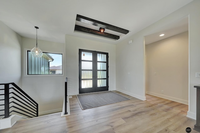 foyer featuring a chandelier, french doors, and light hardwood / wood-style floors