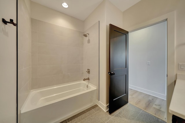 bathroom with hardwood / wood-style flooring and tiled shower / bath