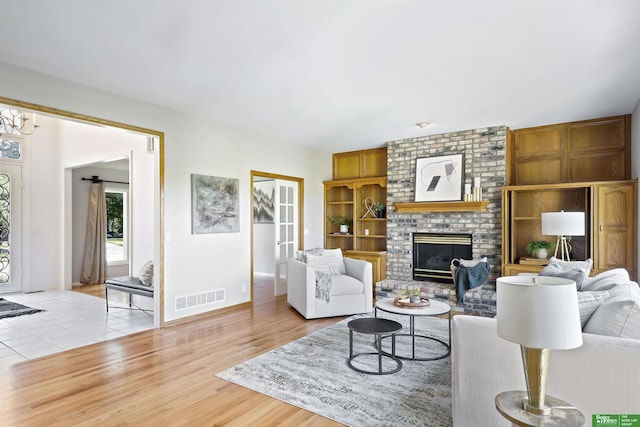 living room with a fireplace and light wood-type flooring