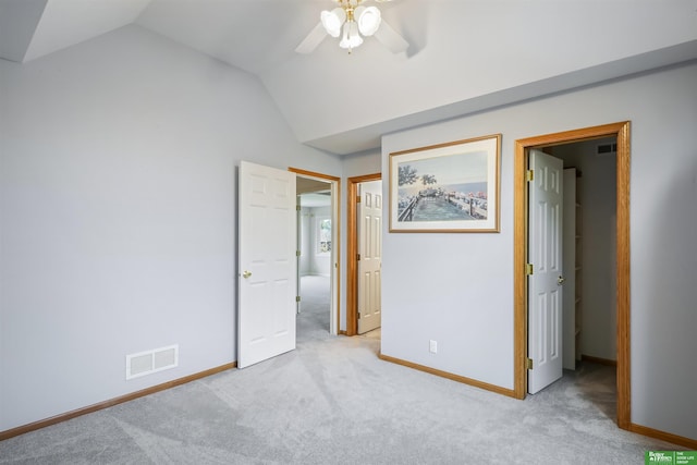 unfurnished bedroom featuring ceiling fan, light colored carpet, and vaulted ceiling