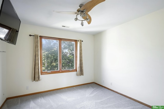 carpeted spare room with ceiling fan