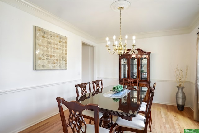 dining room with a chandelier, light hardwood / wood-style floors, and crown molding