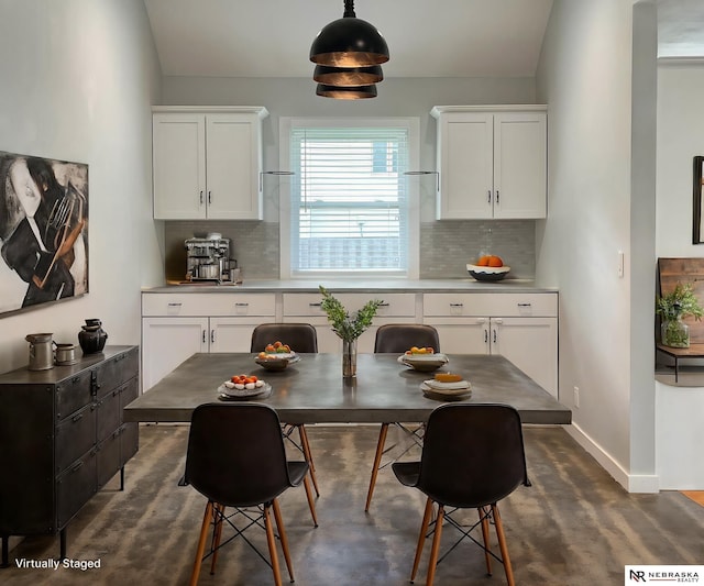 kitchen with decorative backsplash, white cabinetry, and pendant lighting