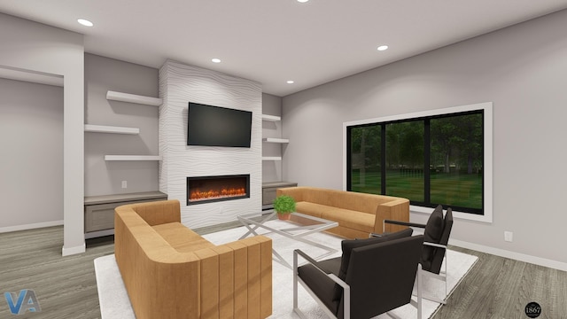 living room featuring built in features, a fireplace, and light hardwood / wood-style flooring