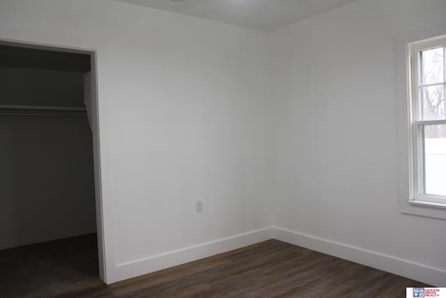 unfurnished bedroom with dark hardwood / wood-style flooring, a closet, and a spacious closet