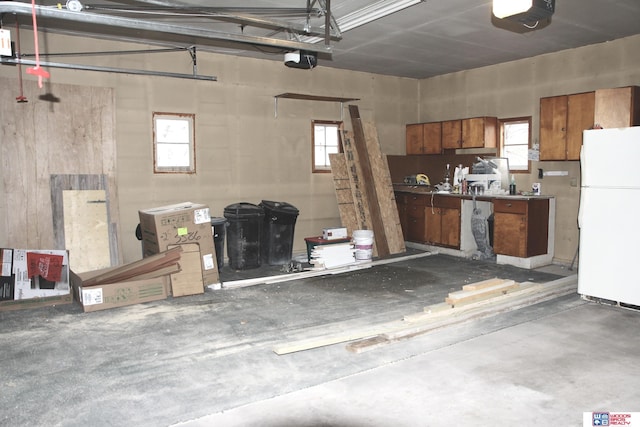 garage with a garage door opener and white fridge