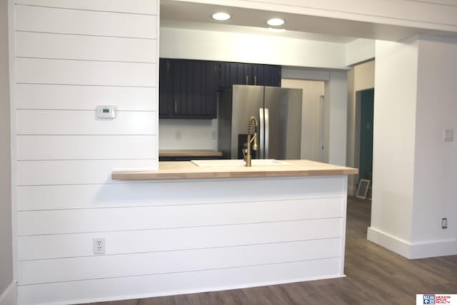 kitchen with sink, stainless steel fridge with ice dispenser, dark hardwood / wood-style flooring, and kitchen peninsula