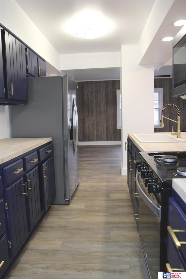 kitchen with stainless steel appliances, sink, and light wood-type flooring