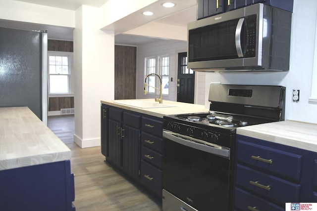 kitchen featuring hardwood / wood-style flooring, appliances with stainless steel finishes, a healthy amount of sunlight, and sink