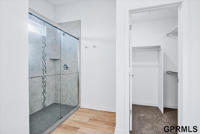 bathroom with wood-type flooring and a shower with door