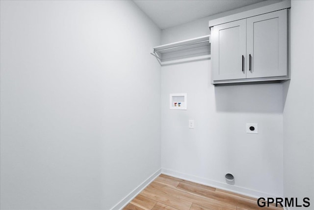 clothes washing area with cabinets, washer hookup, light hardwood / wood-style floors, and electric dryer hookup